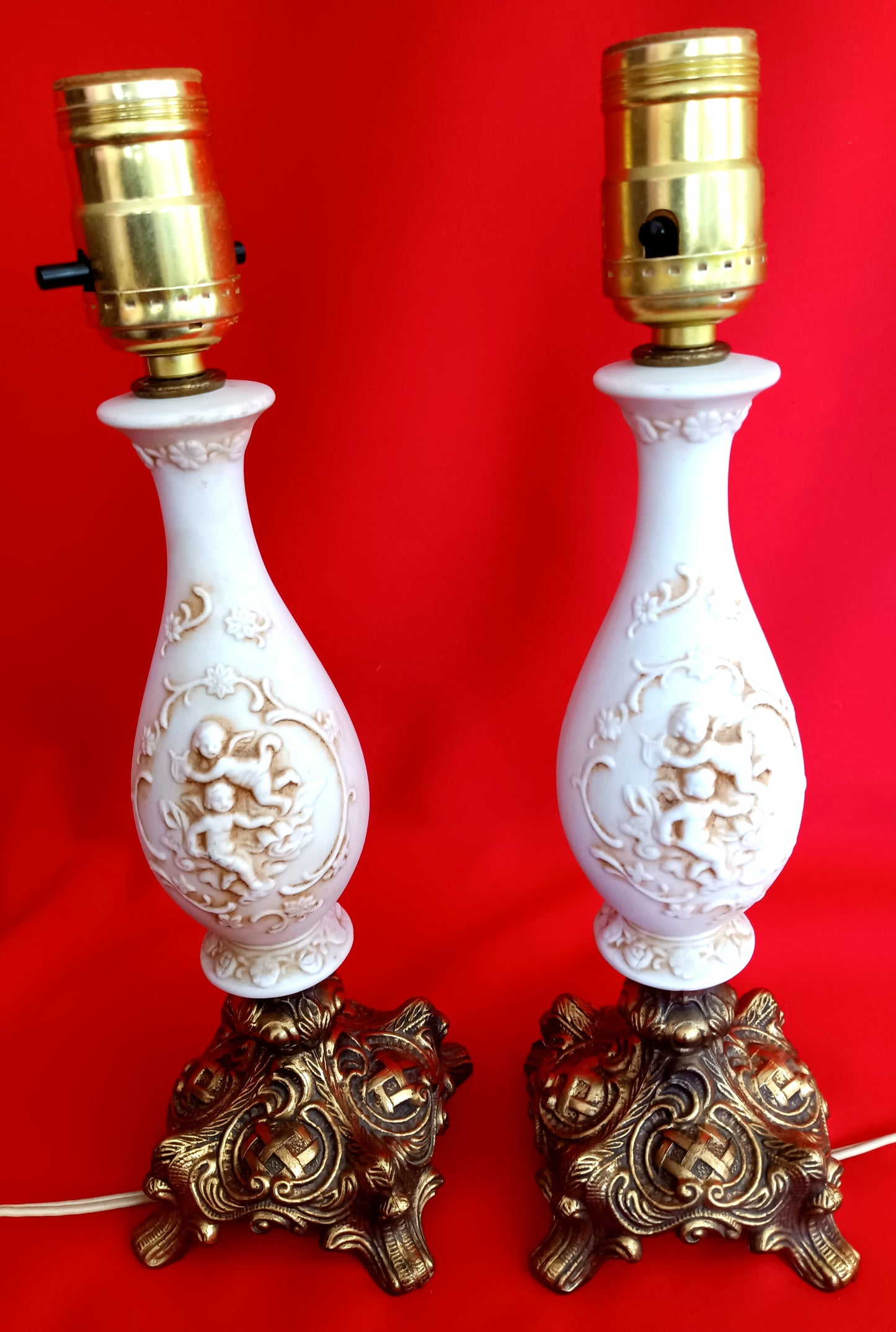 Pair Bisque Porcelain Mid Century Accent Table Lamps Off White w/ Embossed Cherubs/Angels Gold Cast Brass Footed Base Rococo Style Retro